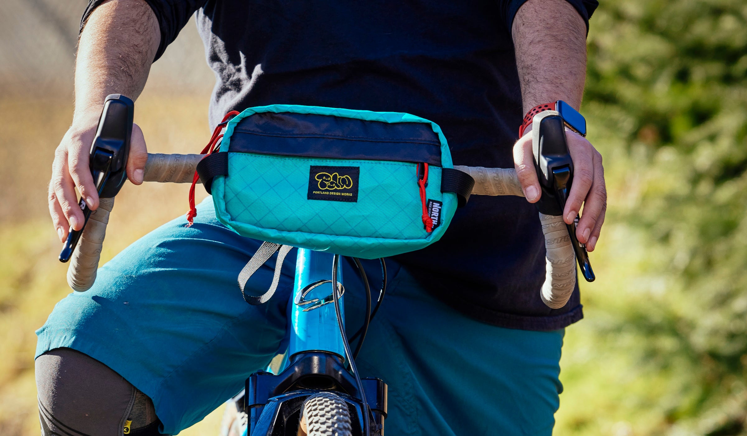 Teal handlebar bag on a drop bar bike